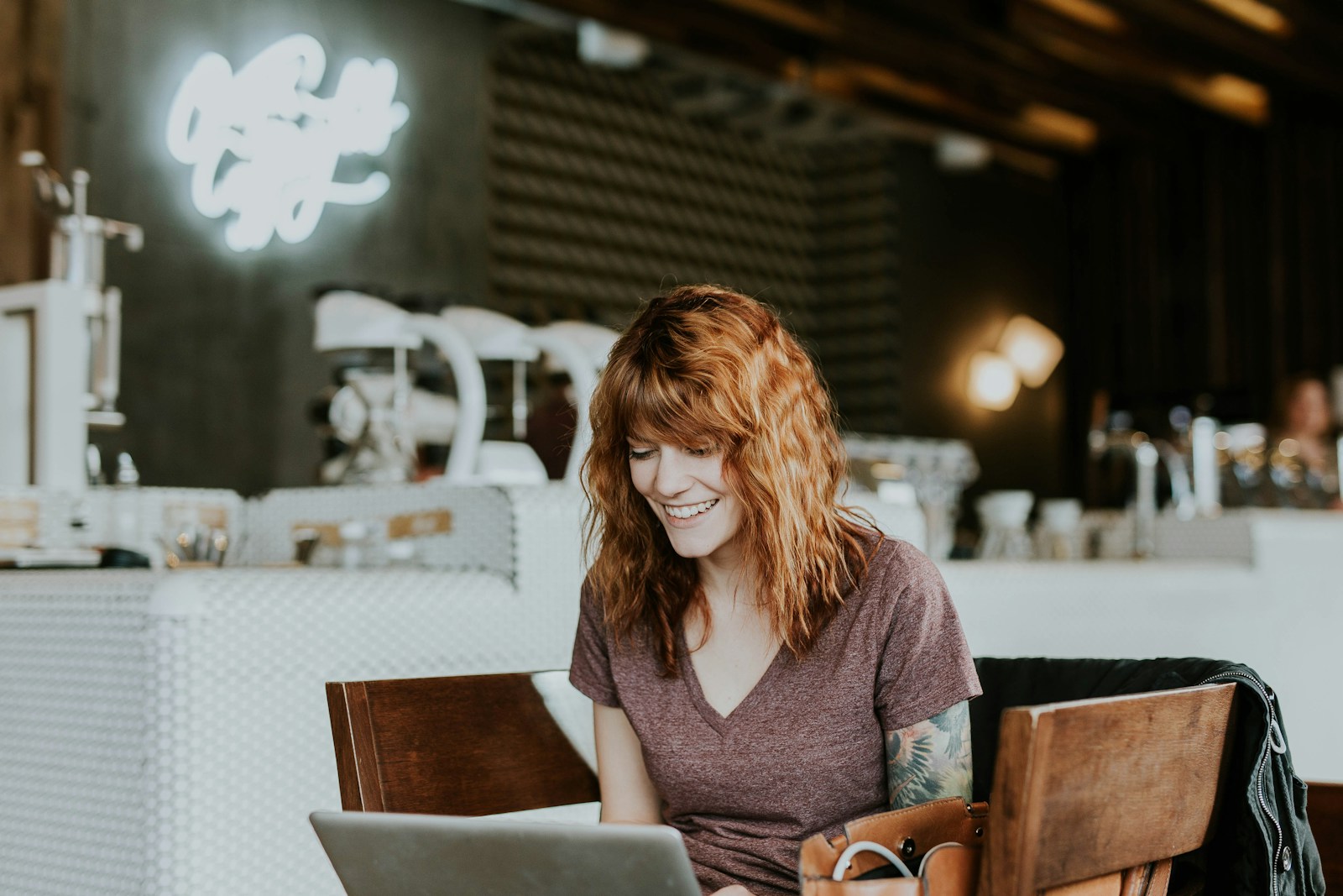 Small business owner working on laptop in cozy coffee shop environment